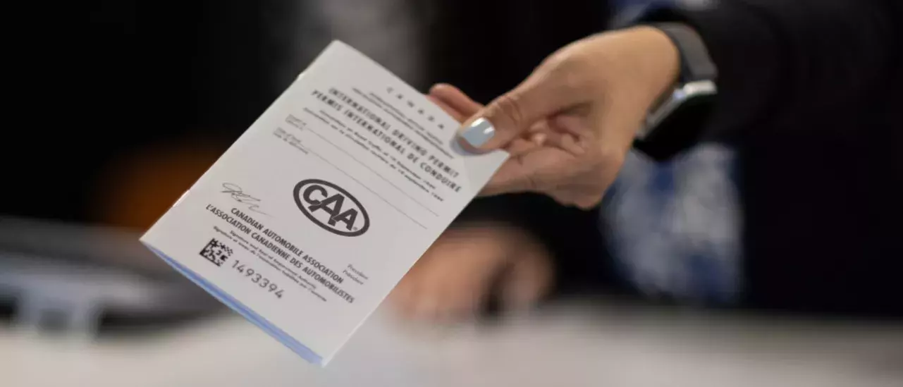 Hand holding out a CAA pamphlet