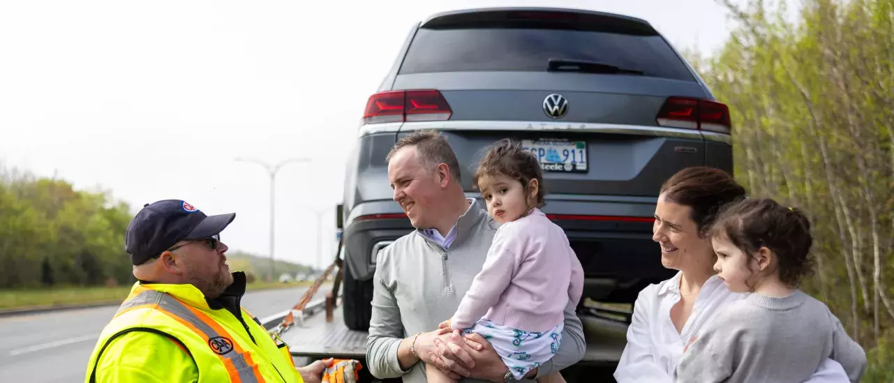 Family with tow truck driver and car on truck Family with tow truck driver and car on truck