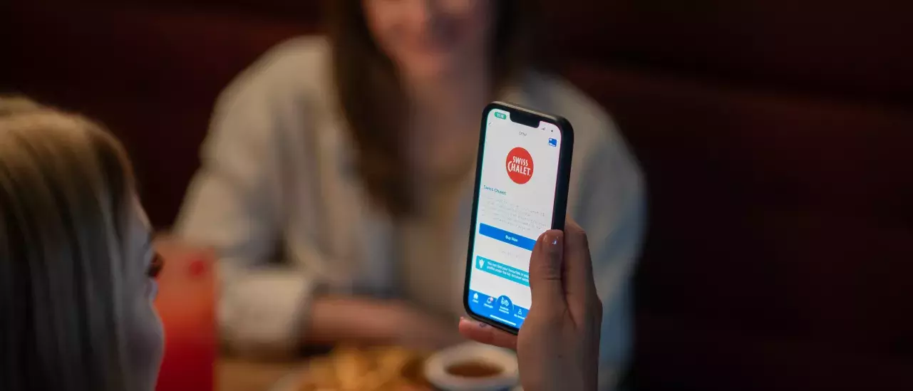 Happy customer showing CAA app at Swiss Chalet Happy customer showing CAA app at Swiss Chalet